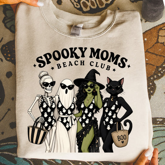 "Spooky Moms Beach Club" graphic with skeleton, ghost, witch, and cat wearing swimsuits.