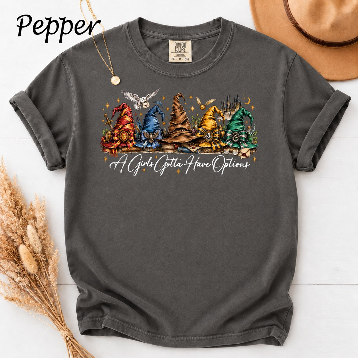 Dark gray t-shirt with wizard hats, books, and "A Girls Gotta Have Options" text.