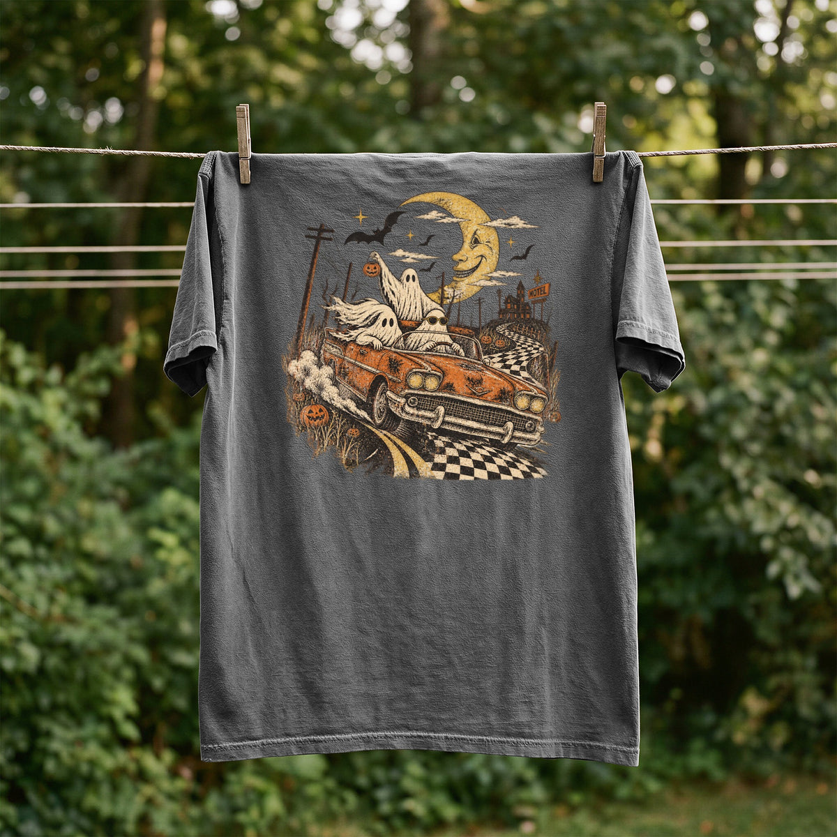 T-shirt with ghosts driving a convertible past a motel under a crescent moon.