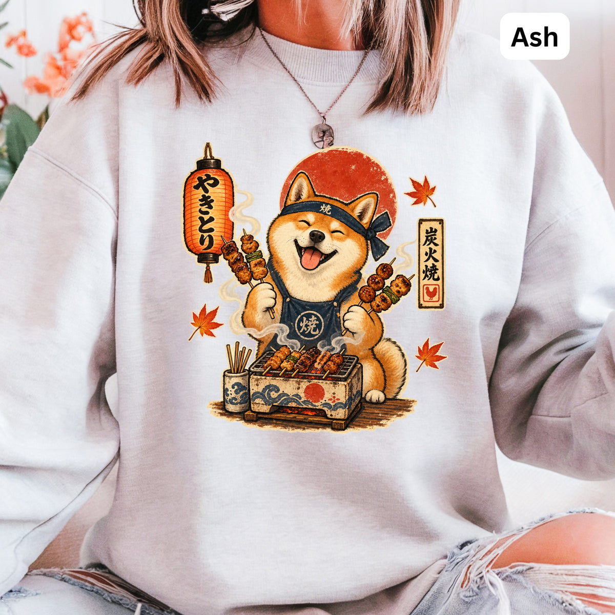 Shiba Inu wearing bandana and apron grilling skewers next to Japanese lantern.