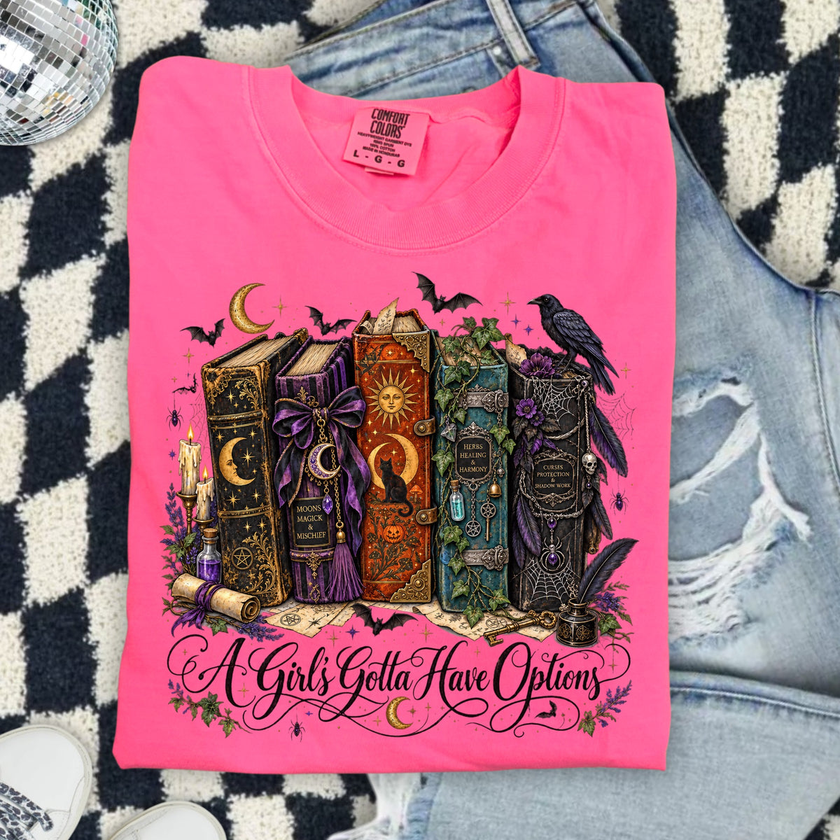 Pink t-shirt with occult book graphic and "A Girl's Gotta Have Options" text.