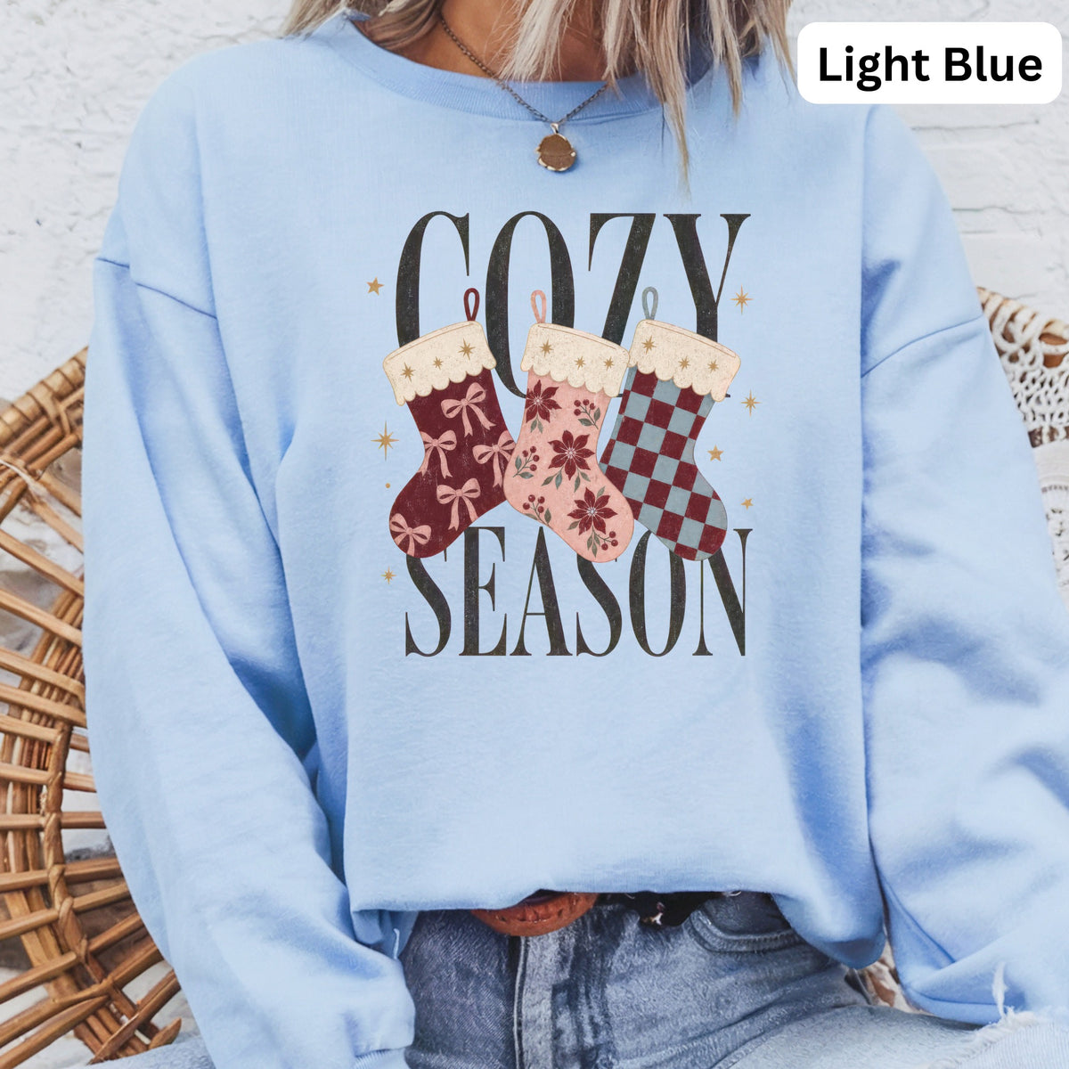 Light blue sweatshirt with "COZY SEASON" and festive stockings graphic.