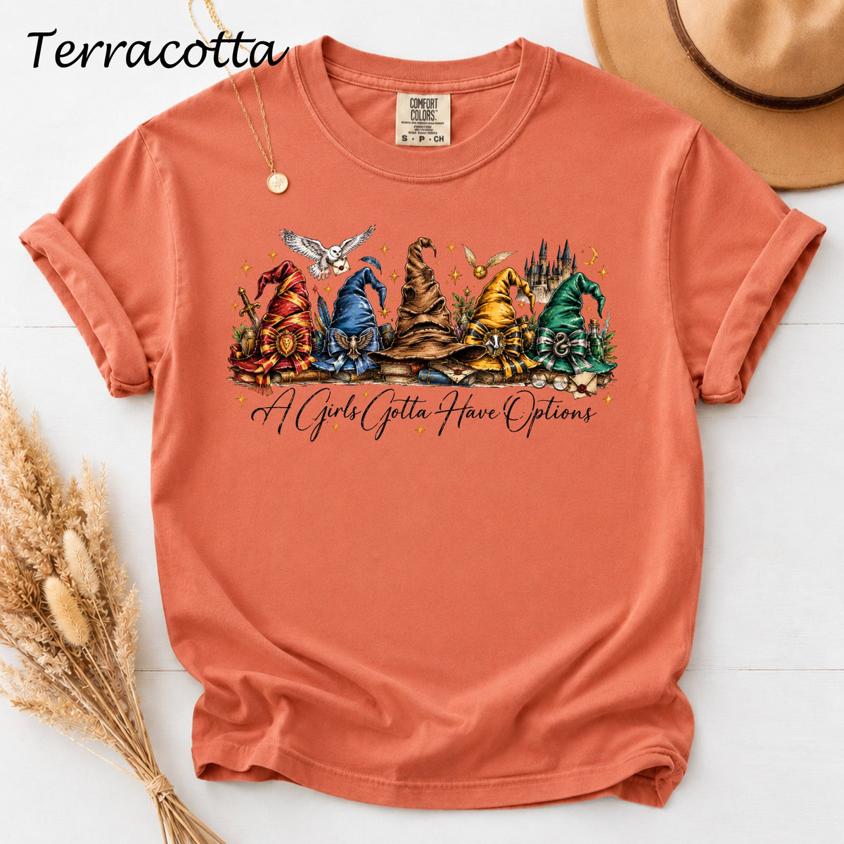 Terracotta t-shirt with five Hogwarts house sorting hats and text.