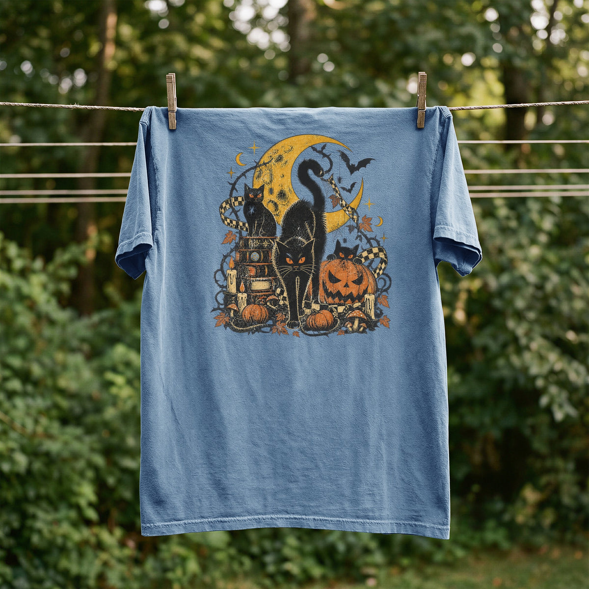Blue t-shirt with black cats, moon, pumpkins, and bats Halloween graphic.