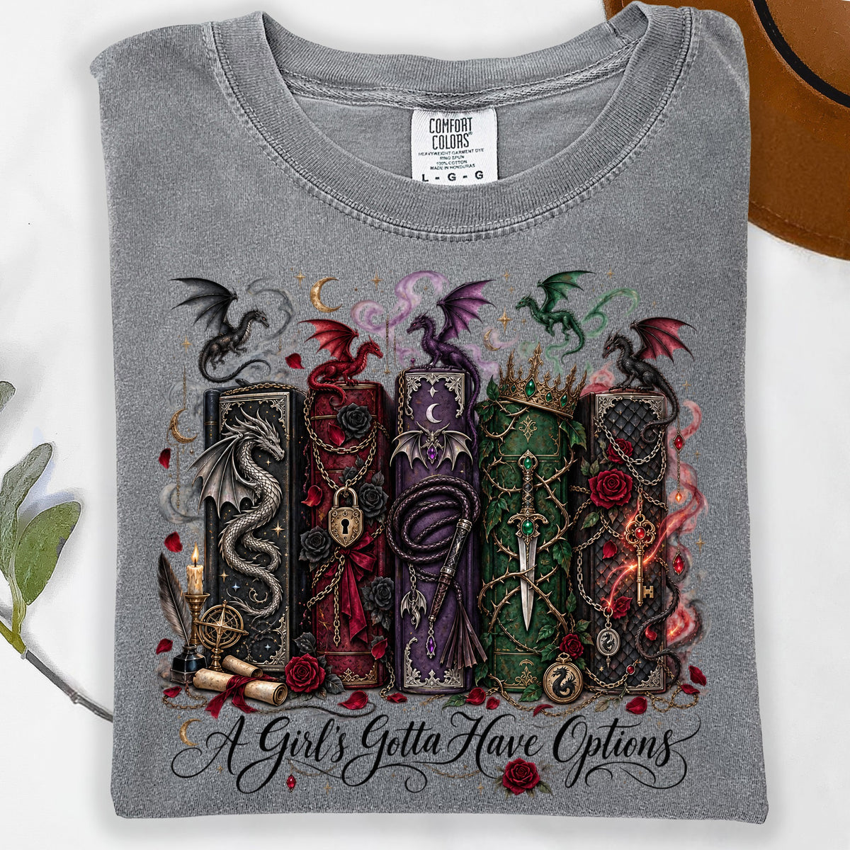 Grey t-shirt with dragons, enchanted books, and "A Girl's Gotta Have Options" text.
