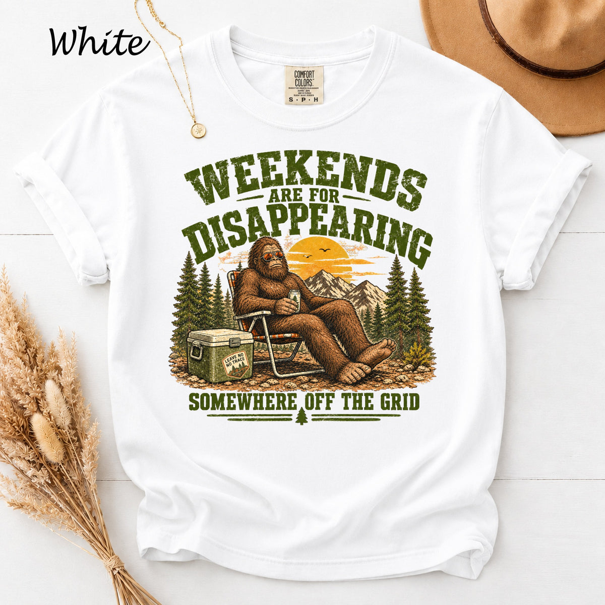 White t-shirt with Bigfoot sitting in a chair, text "Weekends are for disappearing somewhere off the grid".