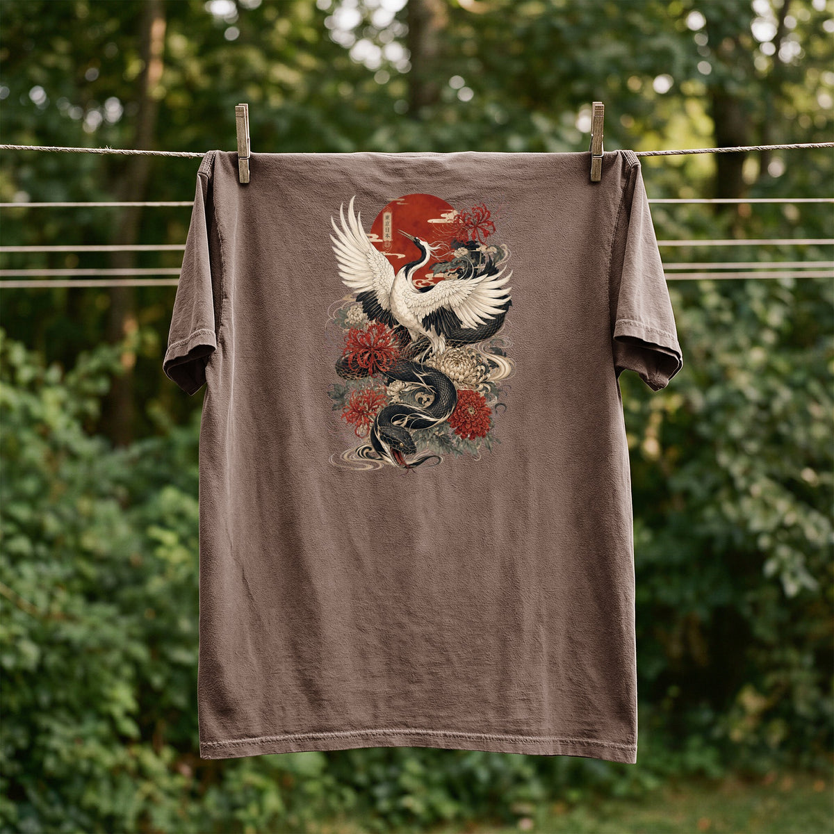 Brown t-shirt with Japanese dragon, crane, and floral design drying on a clothesline.