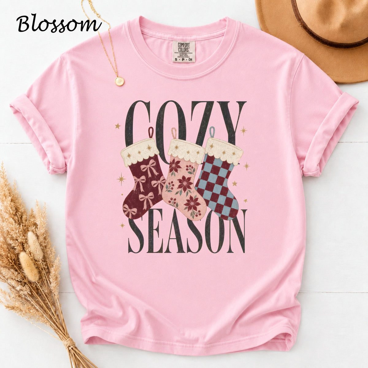 Pink t-shirt with "Cozy Season" graphic and three Christmas stockings.