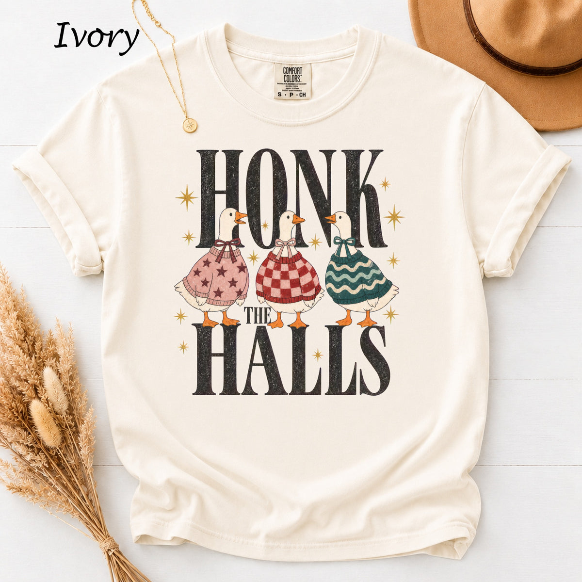 Three cartoon geese in festive sweaters stand under "HONK THE HALLS" text.