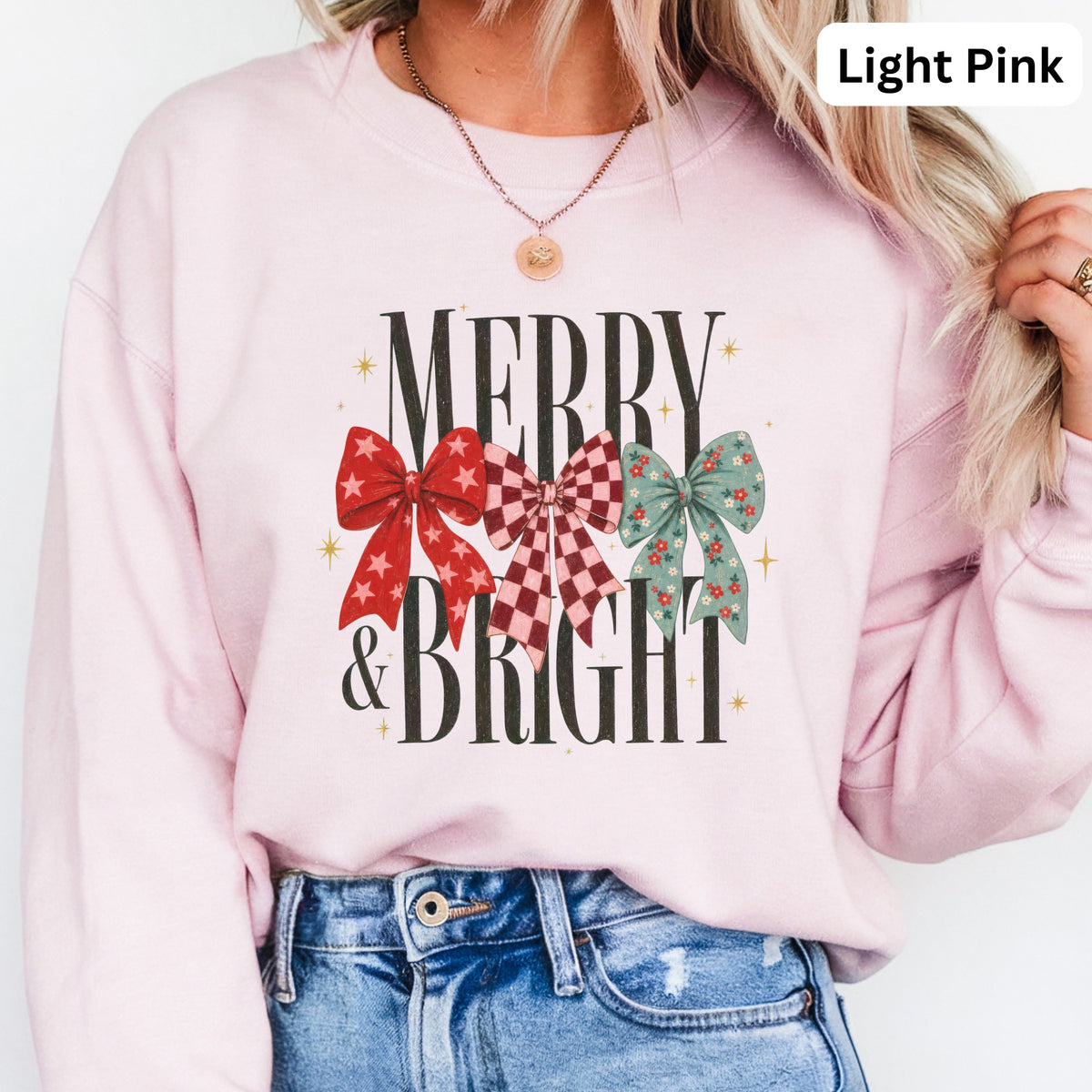 Pink sweatshirt with "MERRY & BRIGHT" text and three decorative bows.