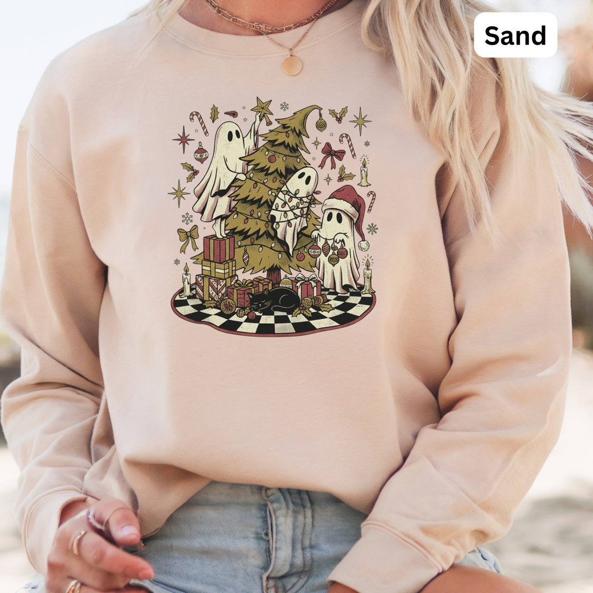 Crewneck sweatshirt with a Christmas-themed ghost graphic and "Sand" color label.