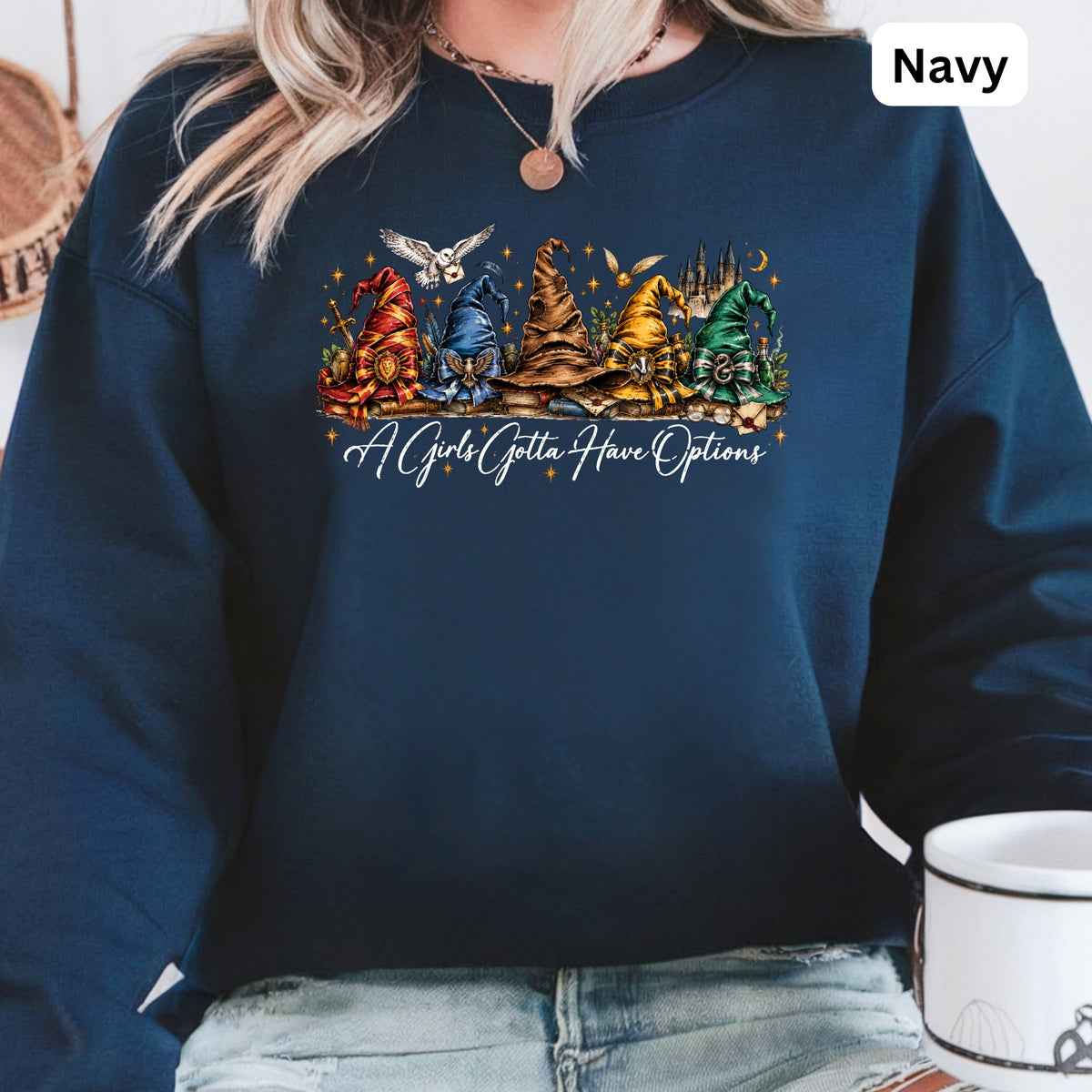 Navy crewneck sweatshirt with a graphic of wizard hats, owls, and castles and the text "A Girls Gotta Have Options".