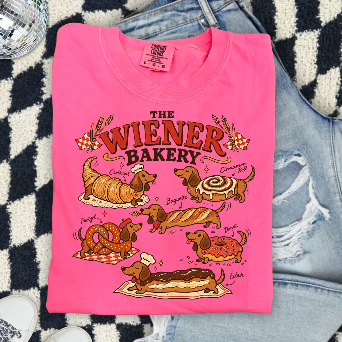 Pink t-shirt with dachshunds dressed as baked goods: croissant, cinnamon roll, baguette, pretzel, donut, and éclair.
