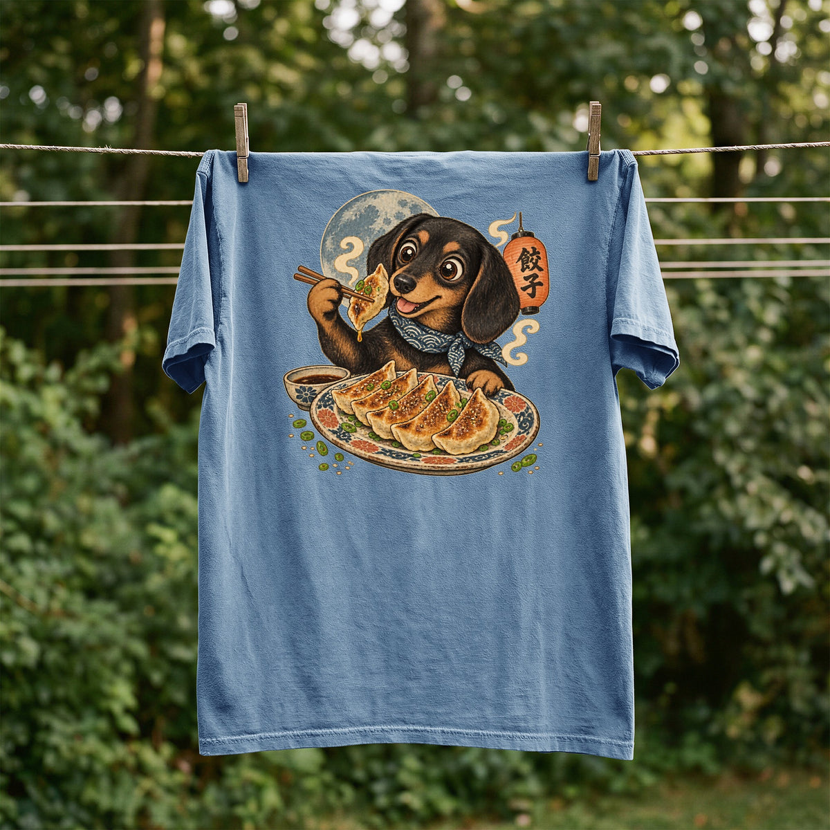 Blue t-shirt with a graphic of a dachshund eating dumplings and a Japanese lantern.