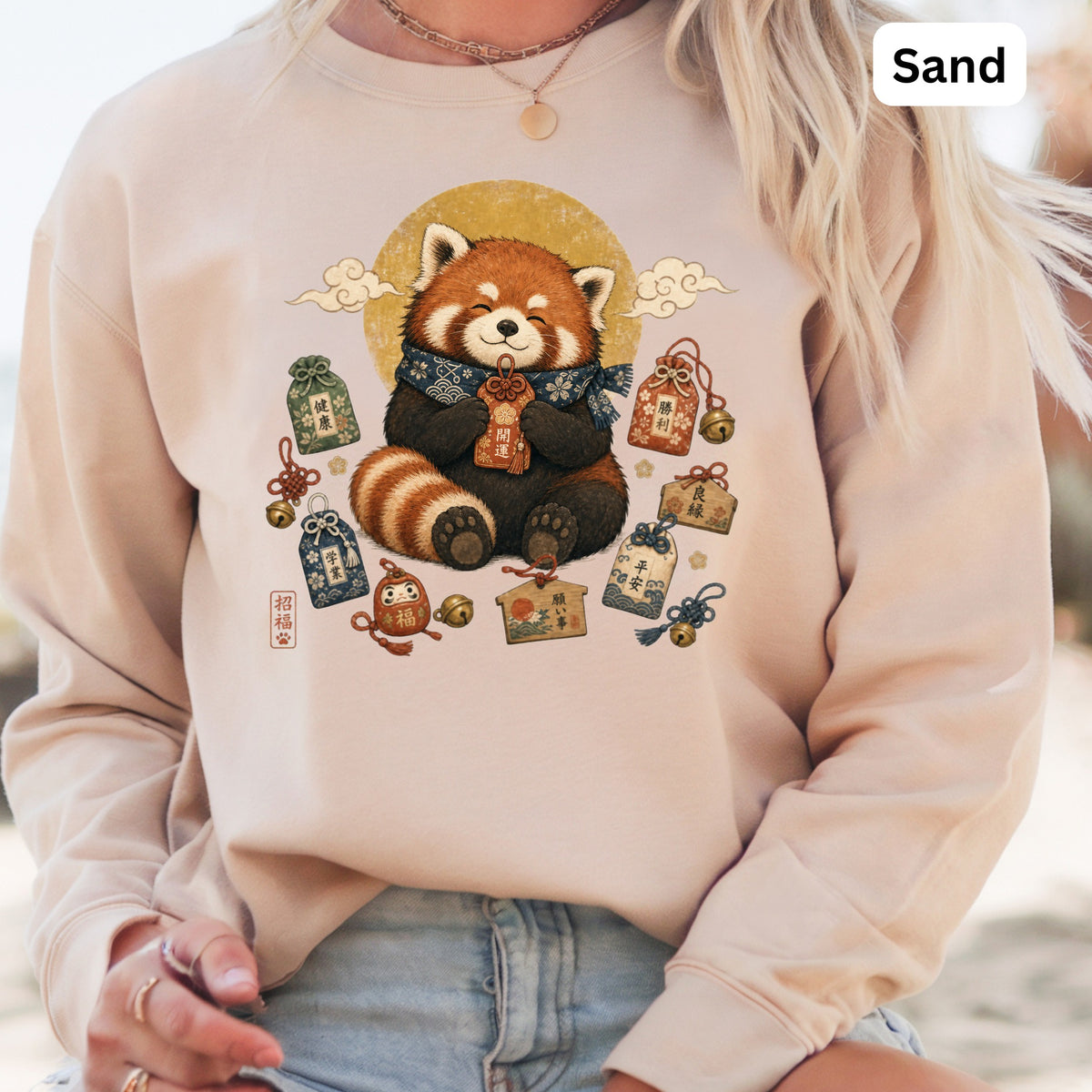 Sand sweatshirt featuring a red panda holding a charm surrounded by lucky amulets and Japanese characters.