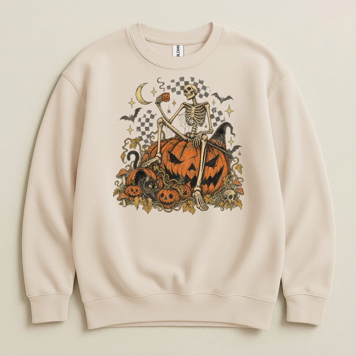 Skeleton sitting on pumpkins with Halloween theme, on a cream crewneck sweatshirt.