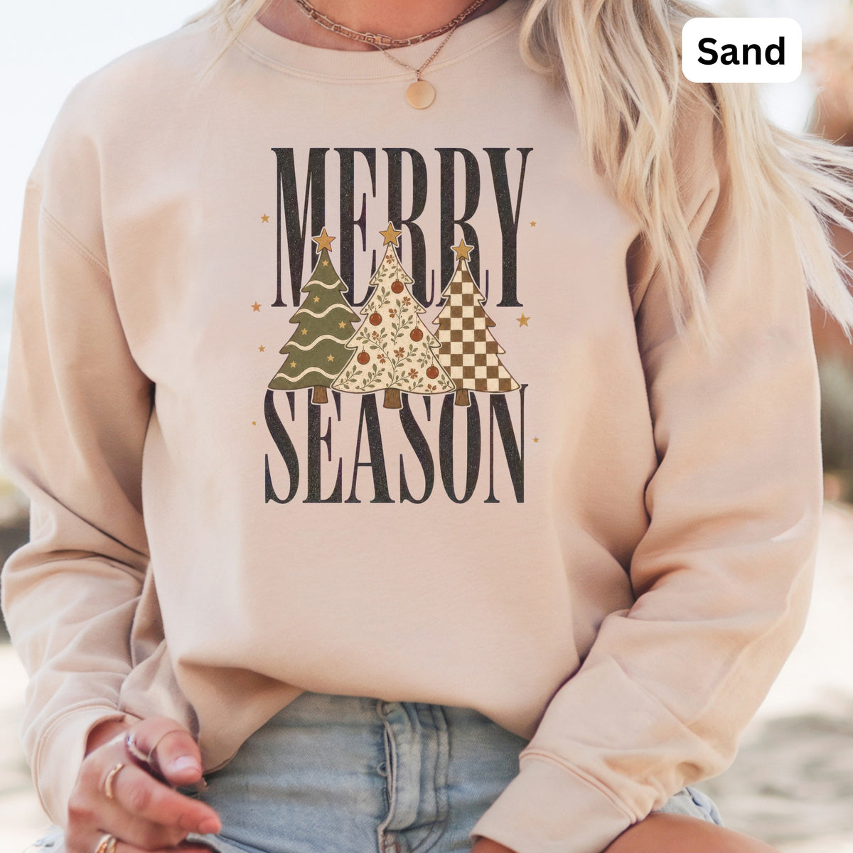 Sand colored sweatshirt with "Merry Season" text and Christmas trees.