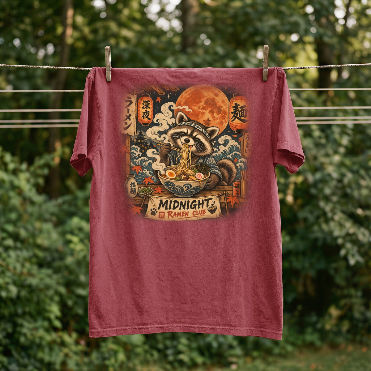 T-shirt with raccoon eating ramen under a moon, "Midnight Ramen Club" text.