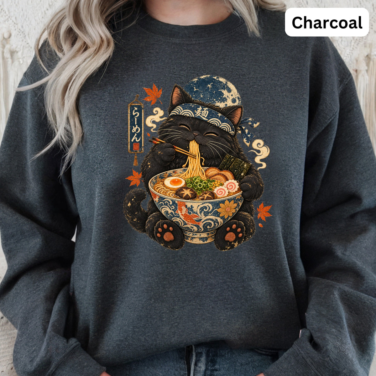Black cat wearing a bandana eats ramen from a decorative bowl.