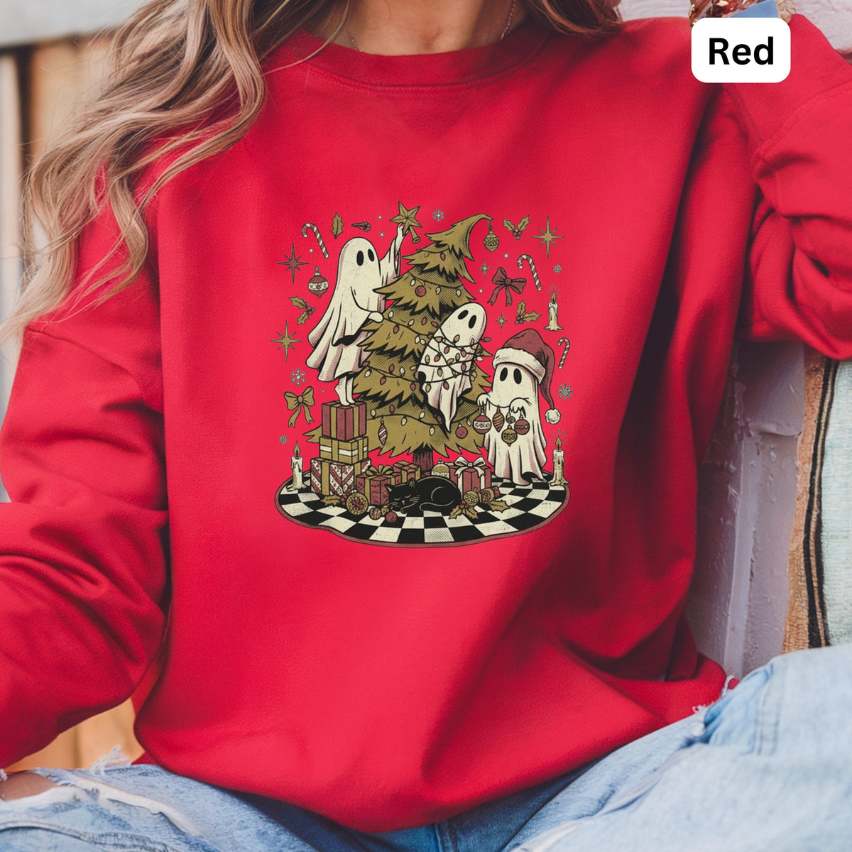 Red sweatshirt with ghosts decorating a Christmas tree and gifts.